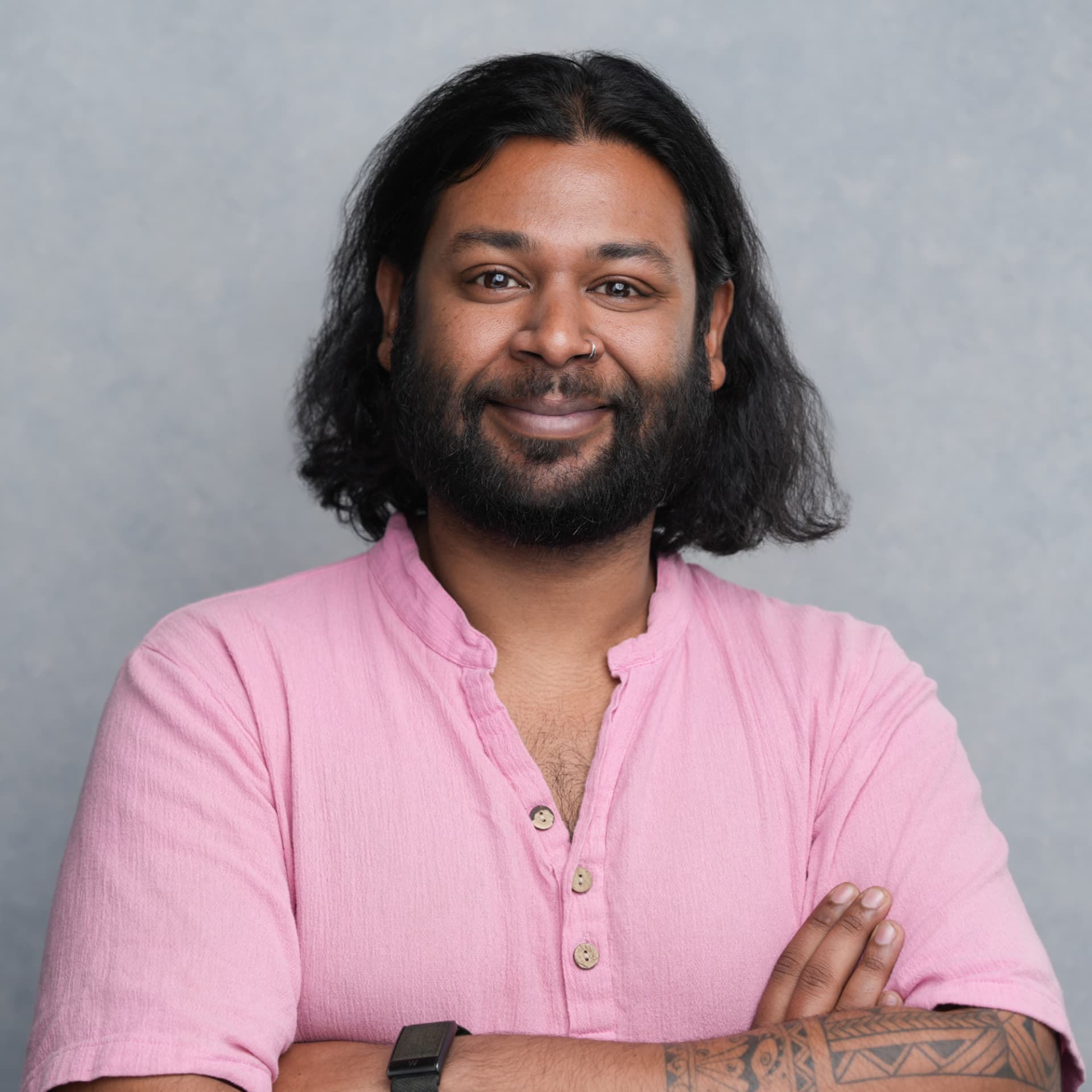 Moiz Arenpurwala, founder of The Growth Gremlin, in a studio portrait with arms crossed